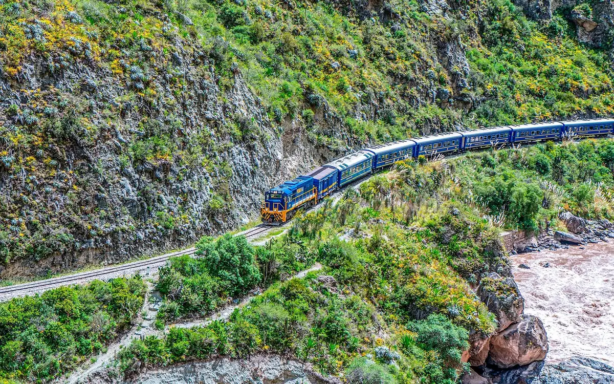 Un train de voyageurs bleu sur une voie au-dessus d&rsquo;une gorge rocheuse