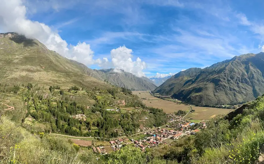 Une petite ville dans une vallée verdoyante entre de hautes montagnes